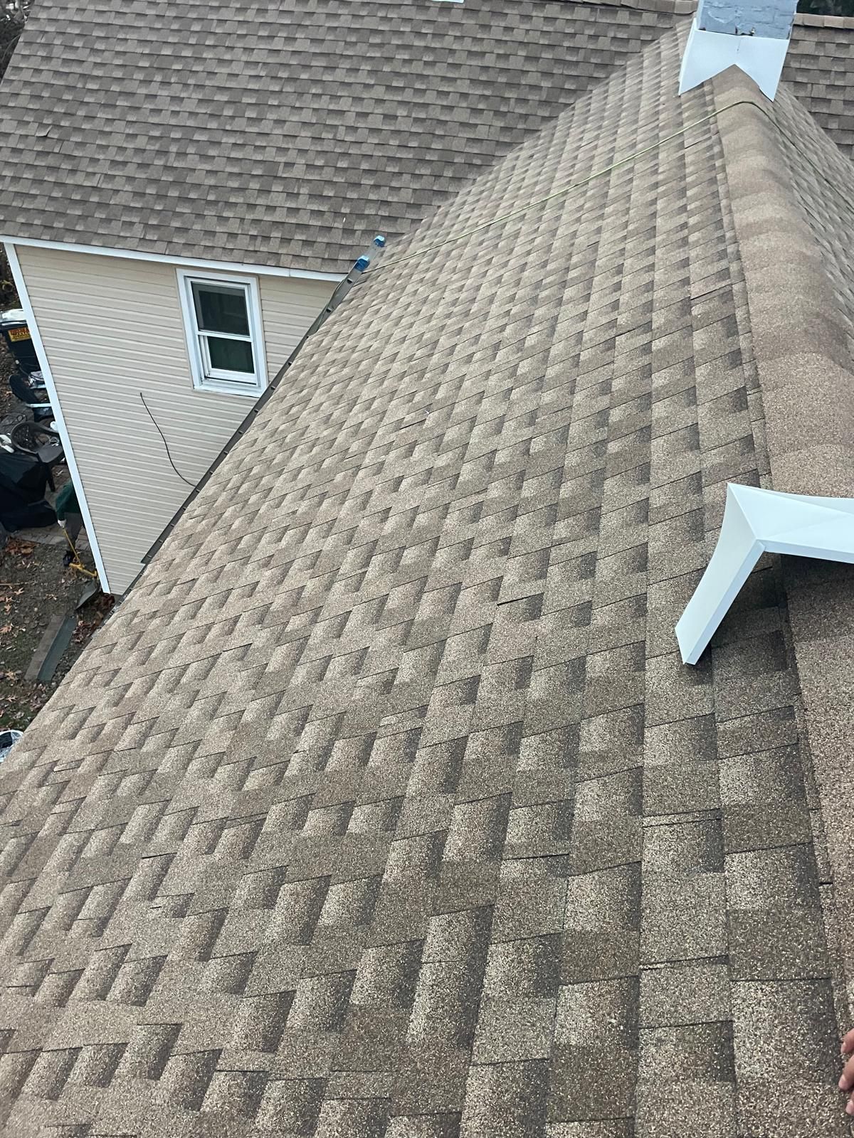 A person is standing on the roof of a house