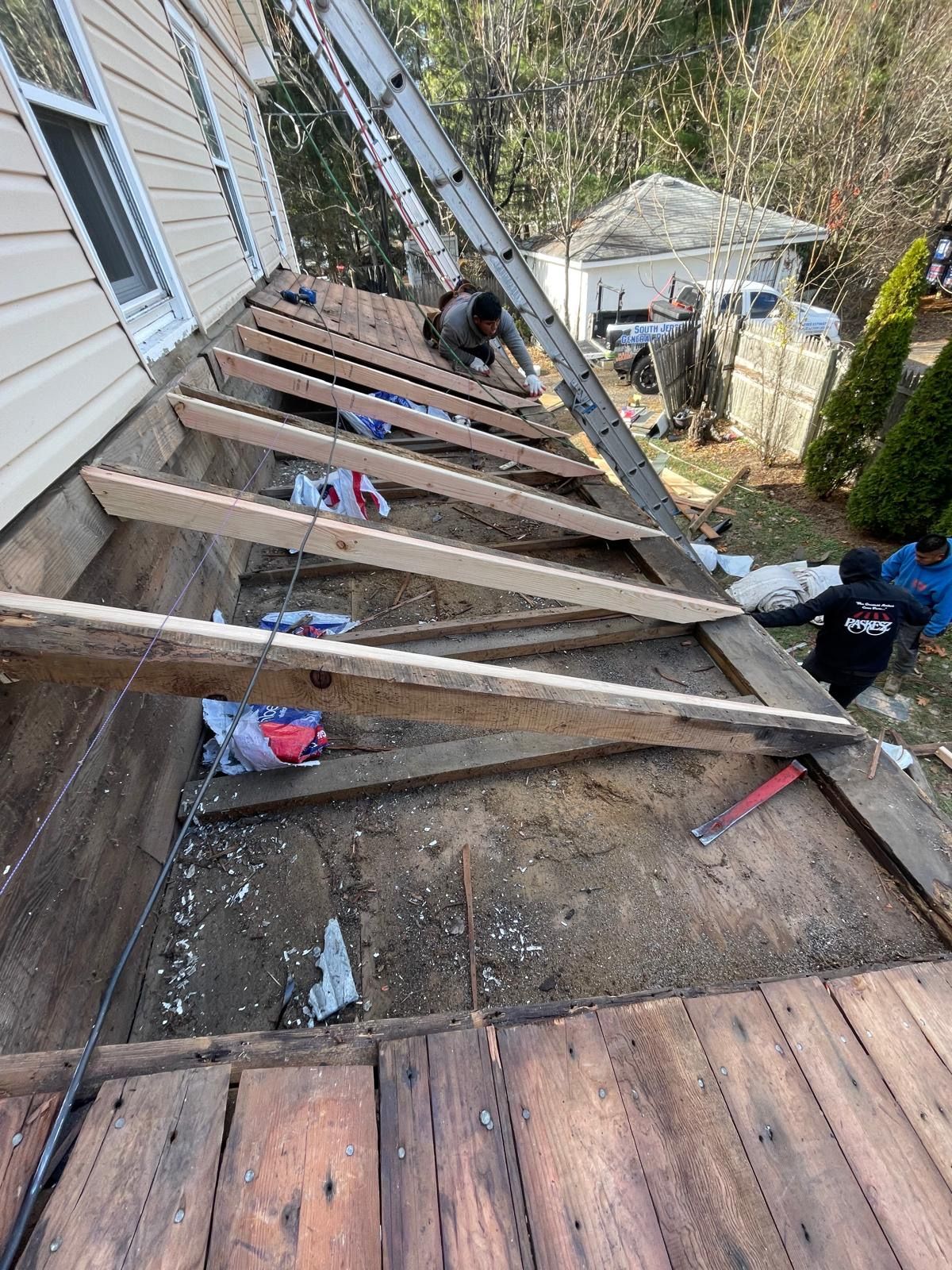 A wooden deck is being built on the side of a house