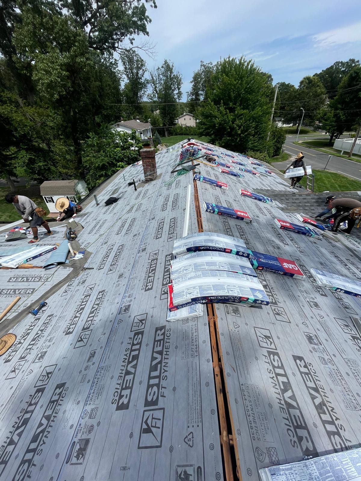 A roof with a lot of shingles on it is being installed.