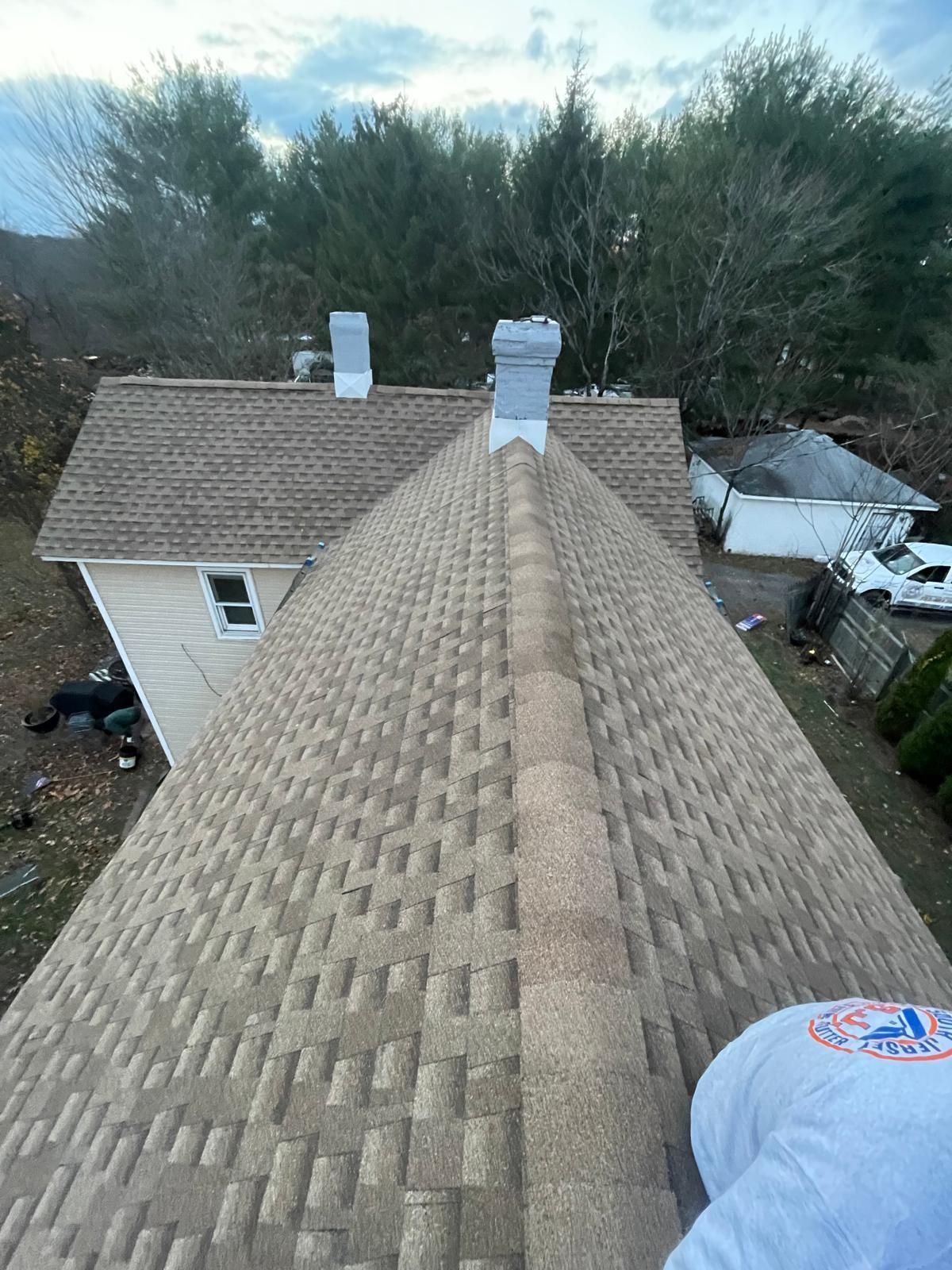 A person is standing on the roof of a house