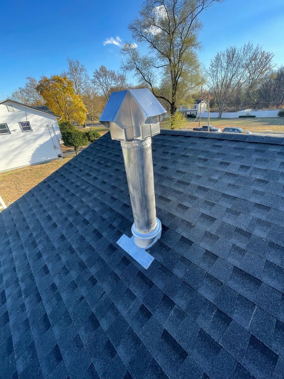 There is a chimney on the roof of a house.
