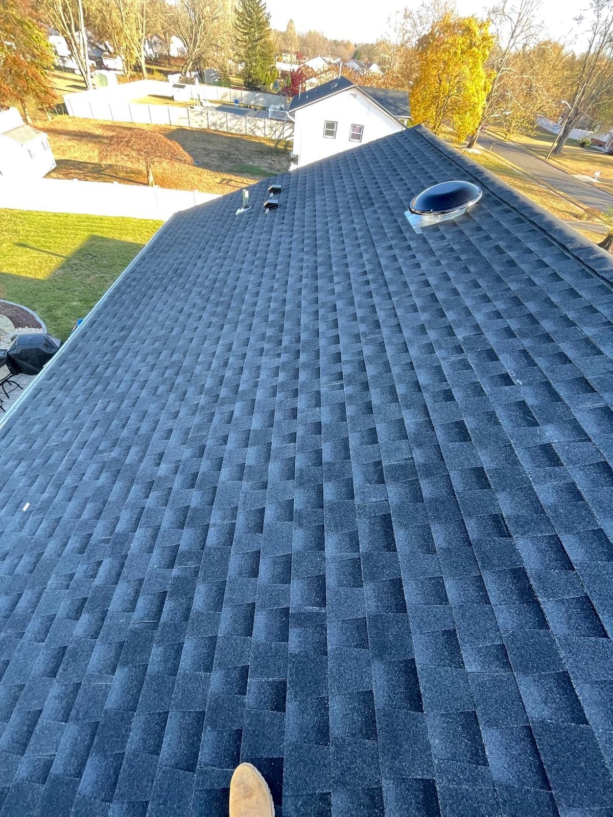 A person is standing on the roof of a house.