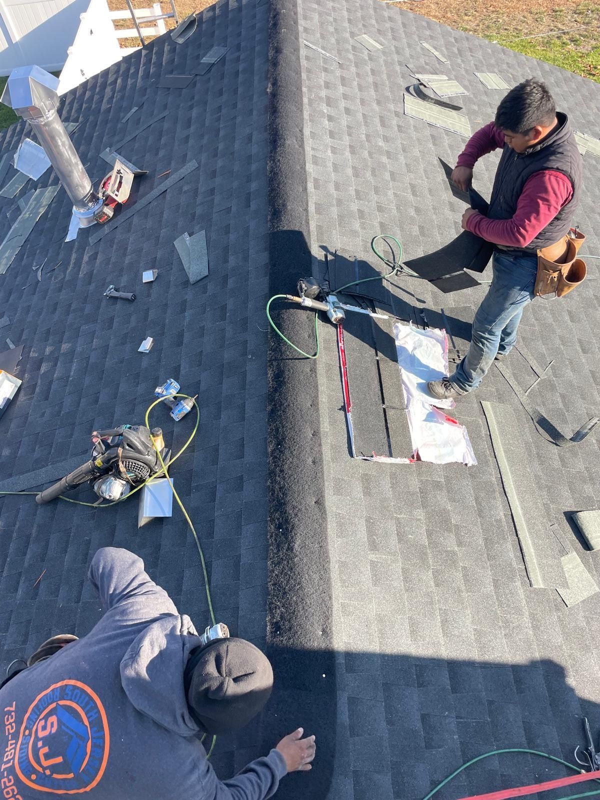 Two men are working on the roof of a house.