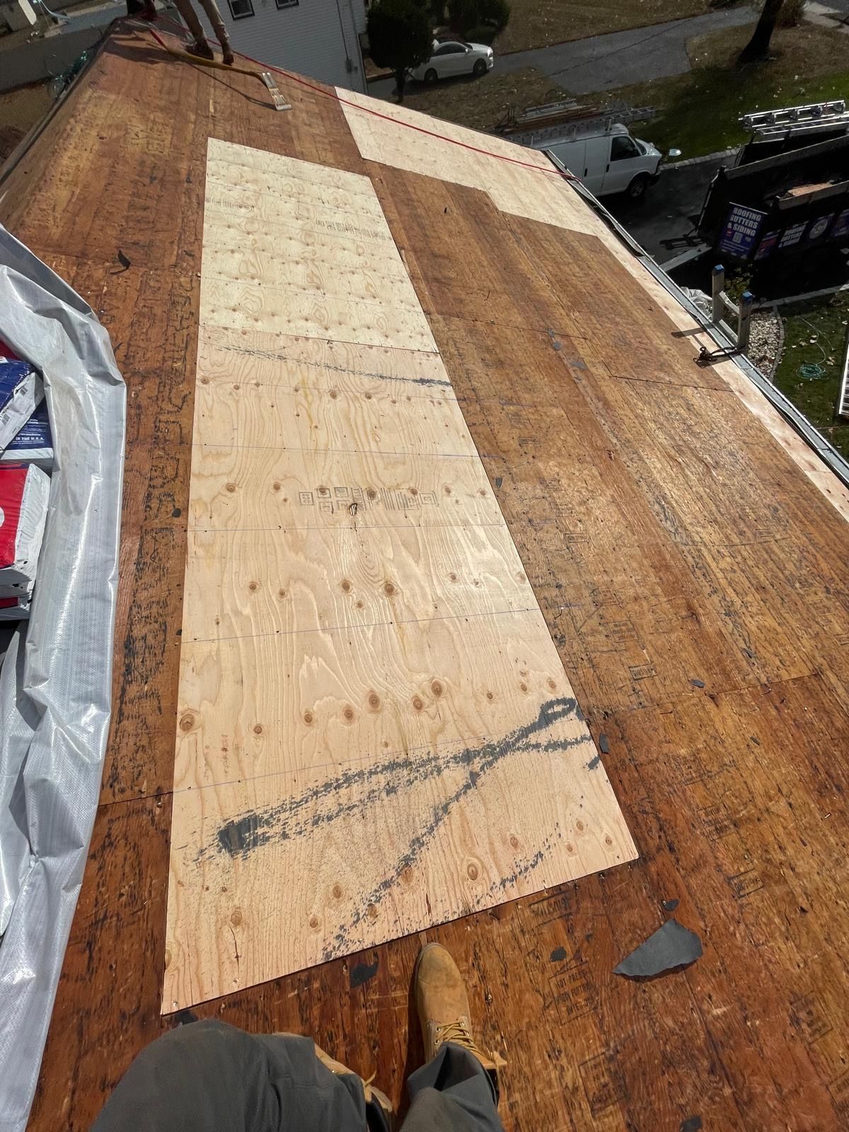 A person is sitting on top of a wooden roof.