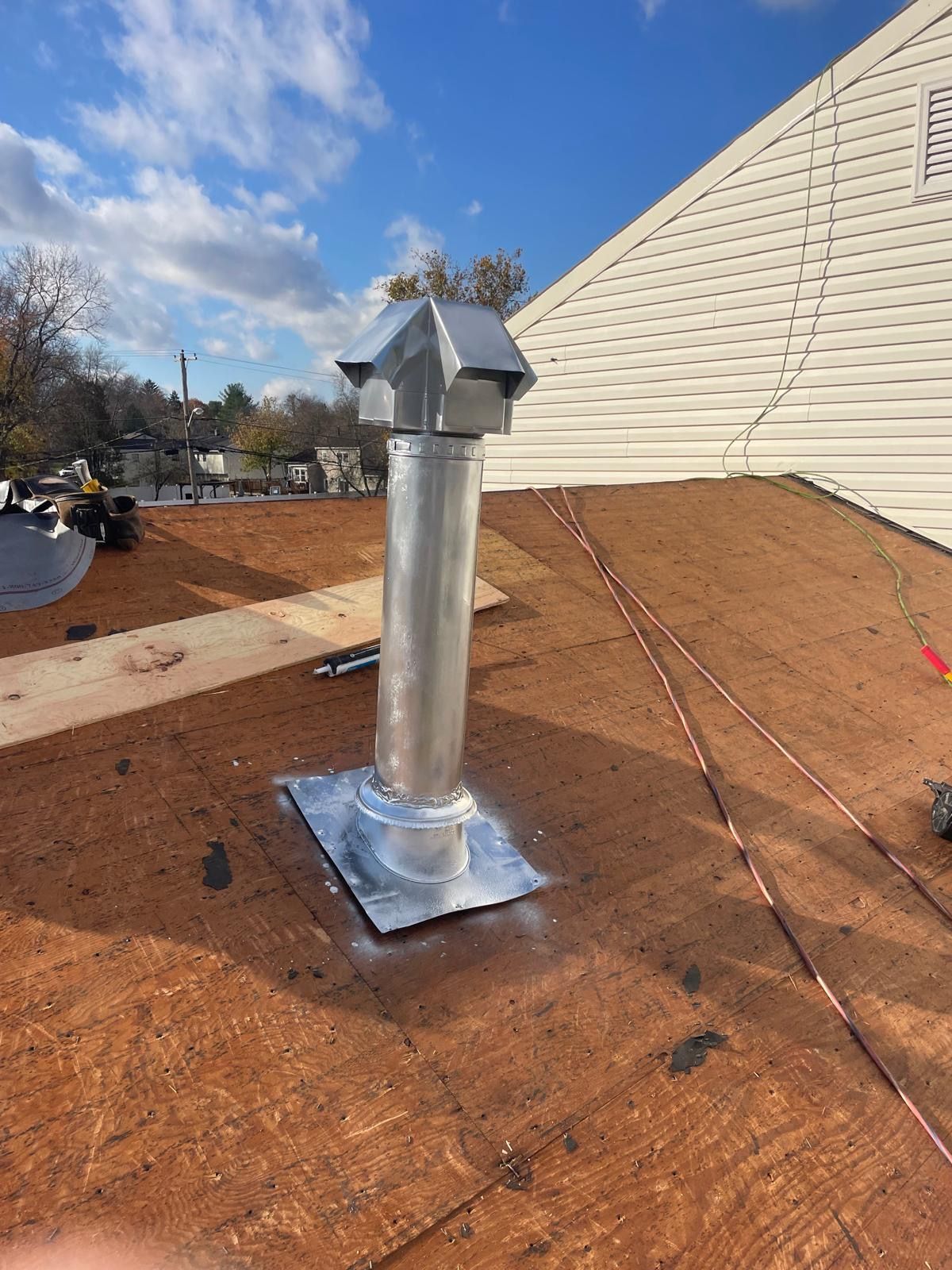 A metal chimney is on the roof of a building.