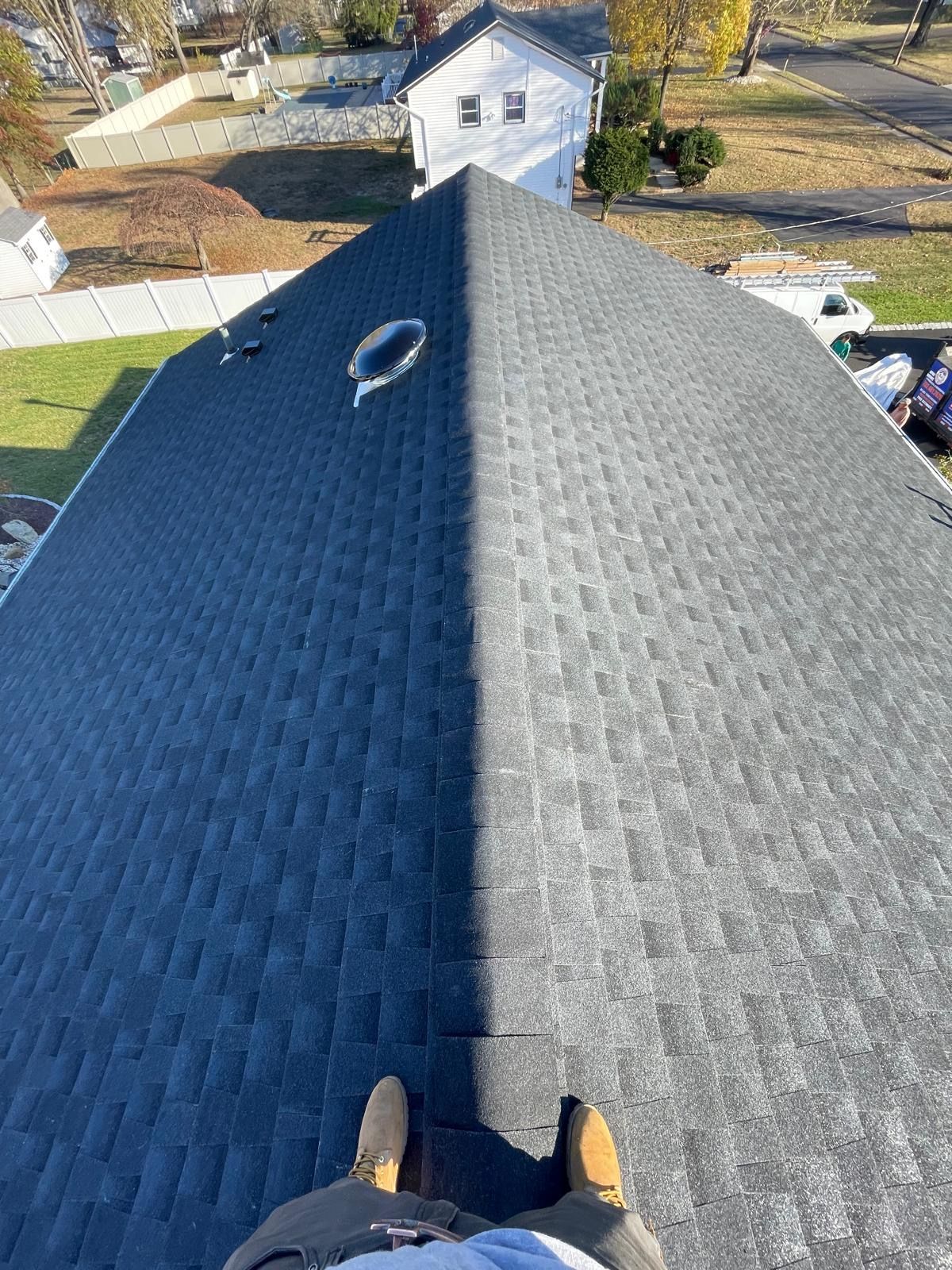 A person is standing on the roof of a house.