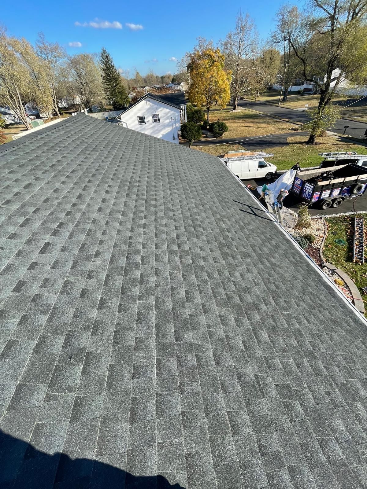 A roof with a lot of shingles on it is being installed on a house.