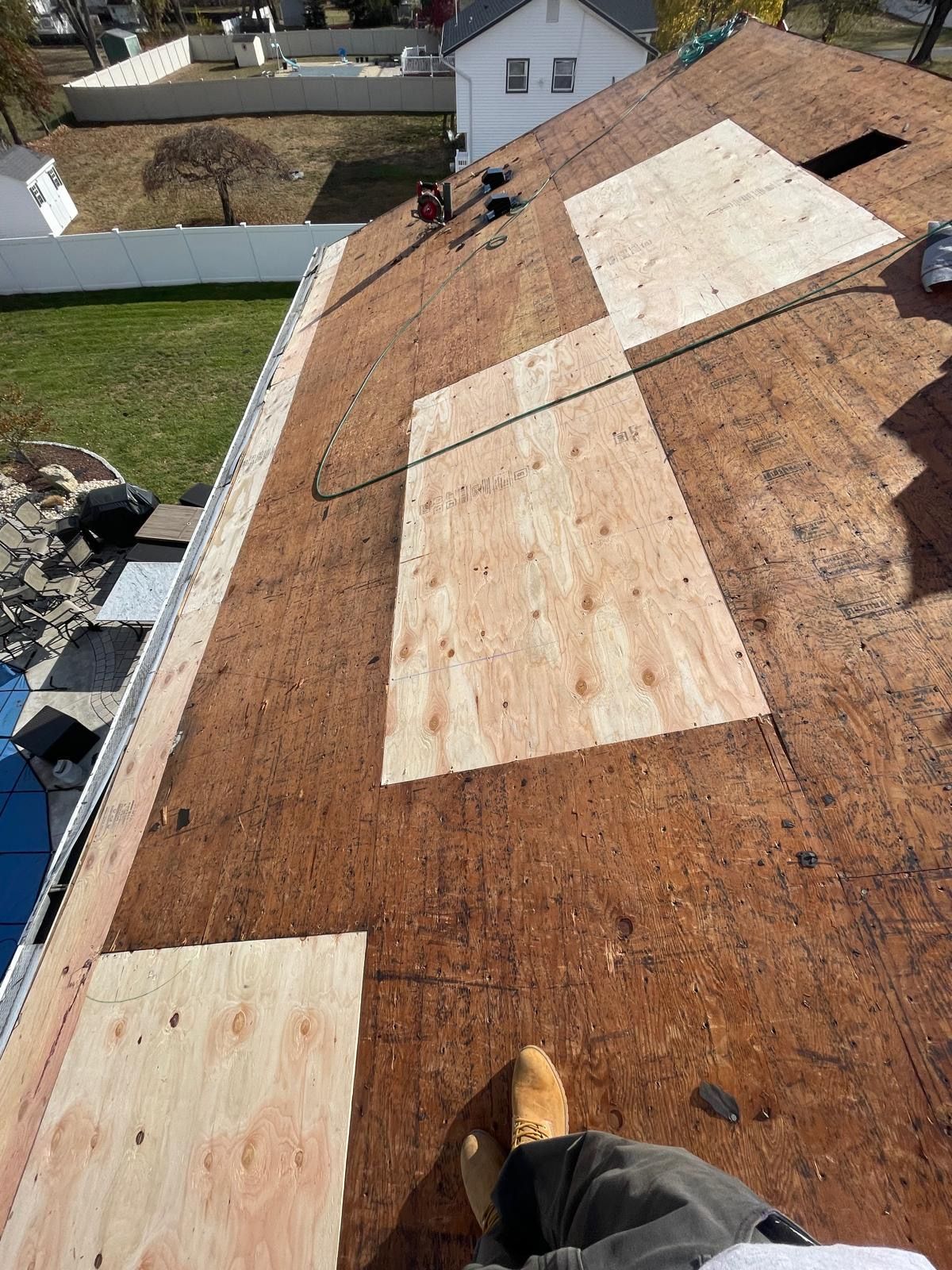 A person is standing on top of a wooden roof.
