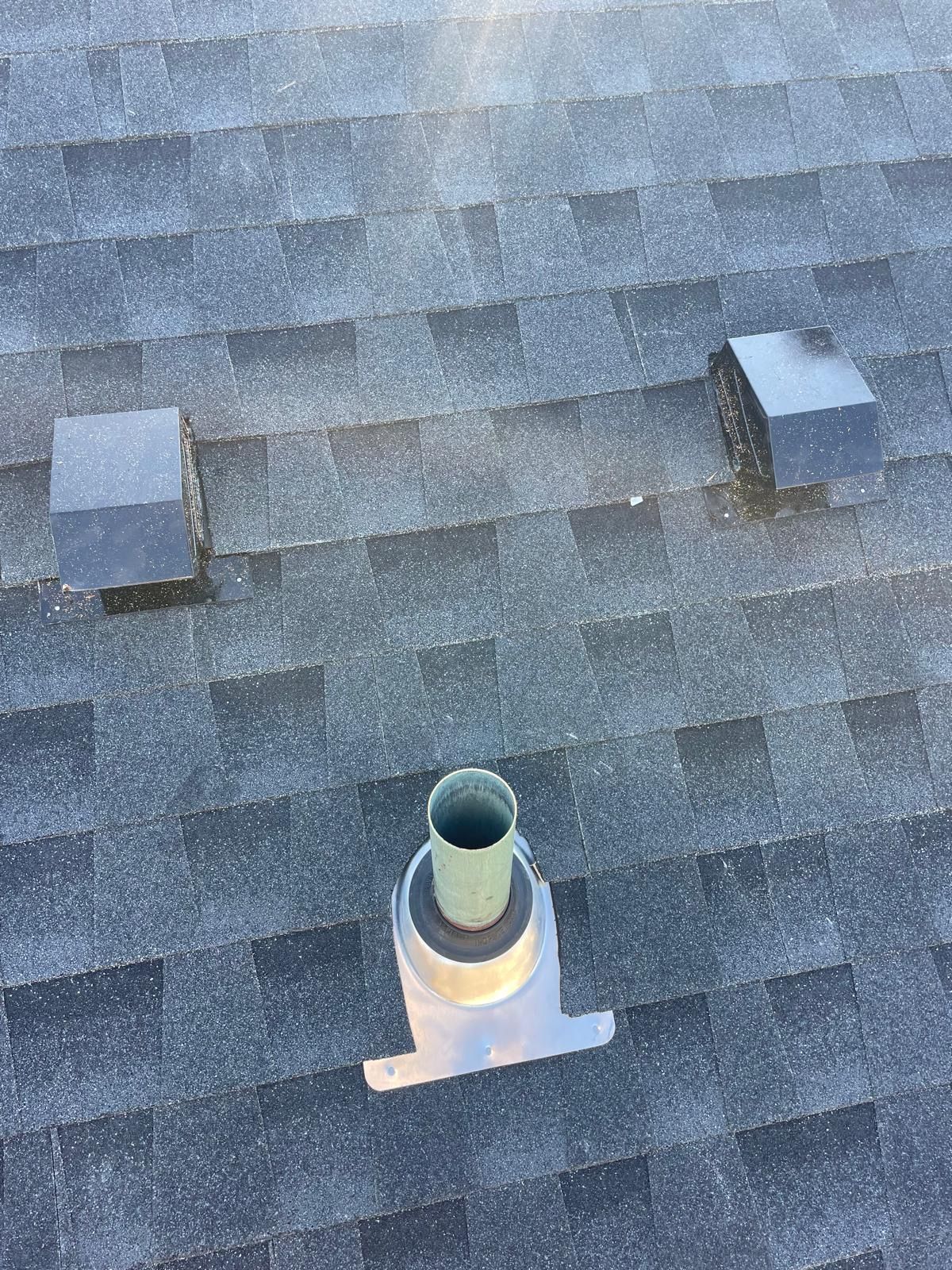 A close up of a roof with a chimney on it.