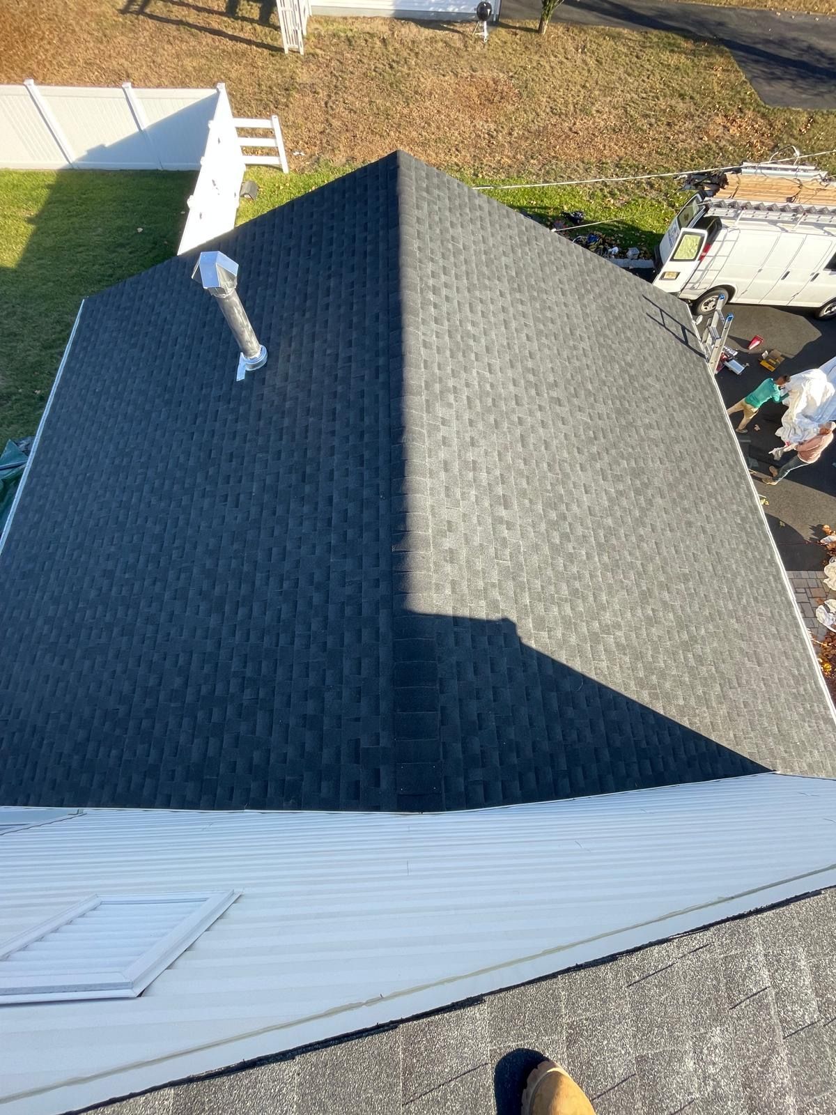A person is standing on the roof of a house.
