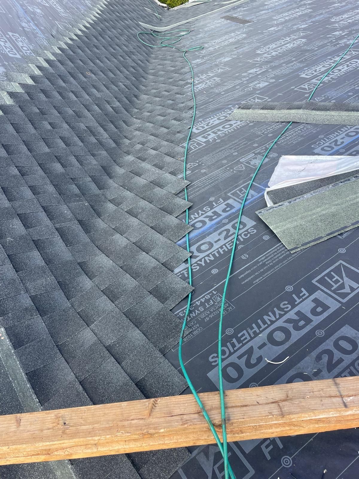 A roof with a green hose attached to it.