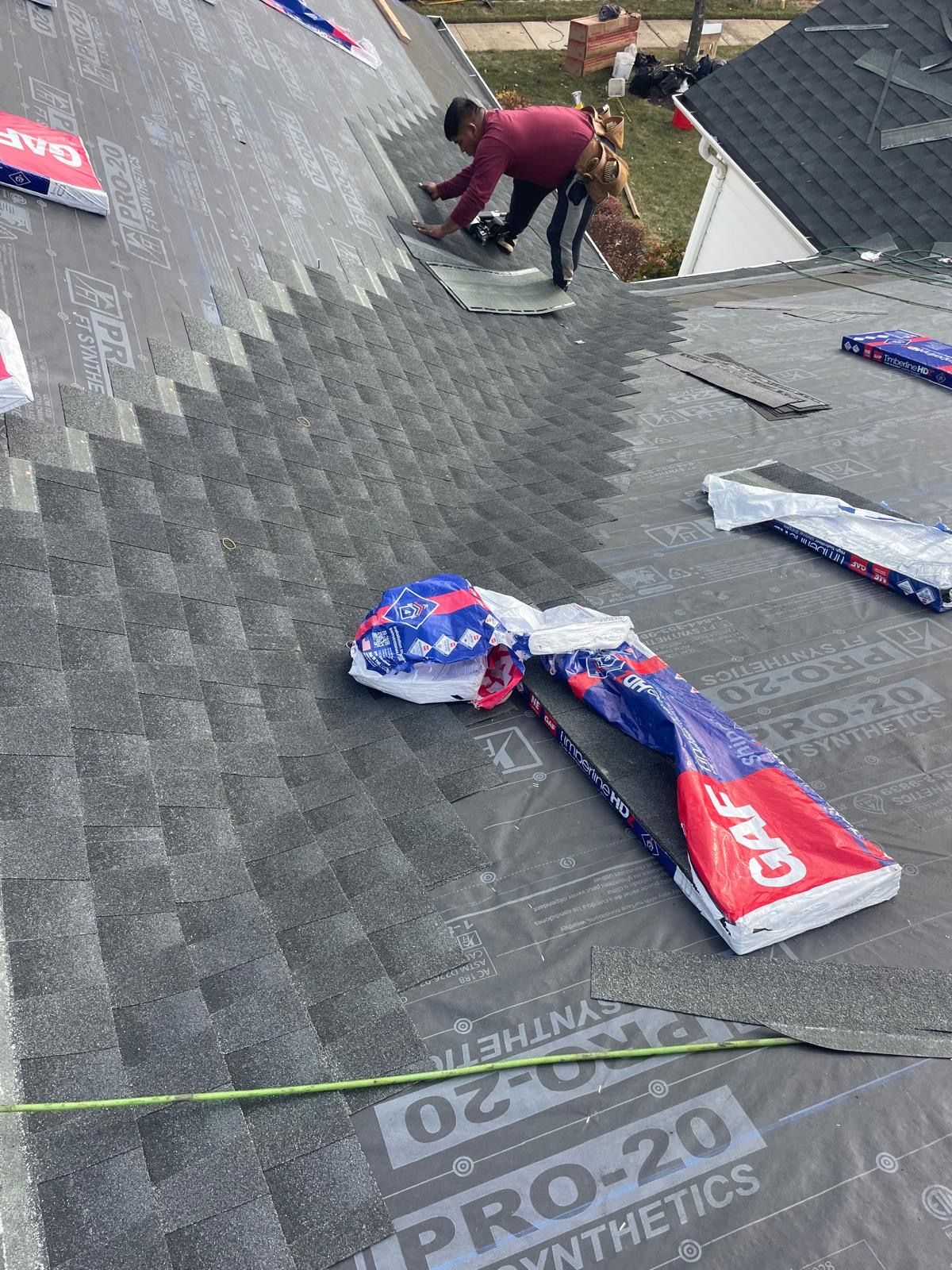 A man is working on the roof of a house.