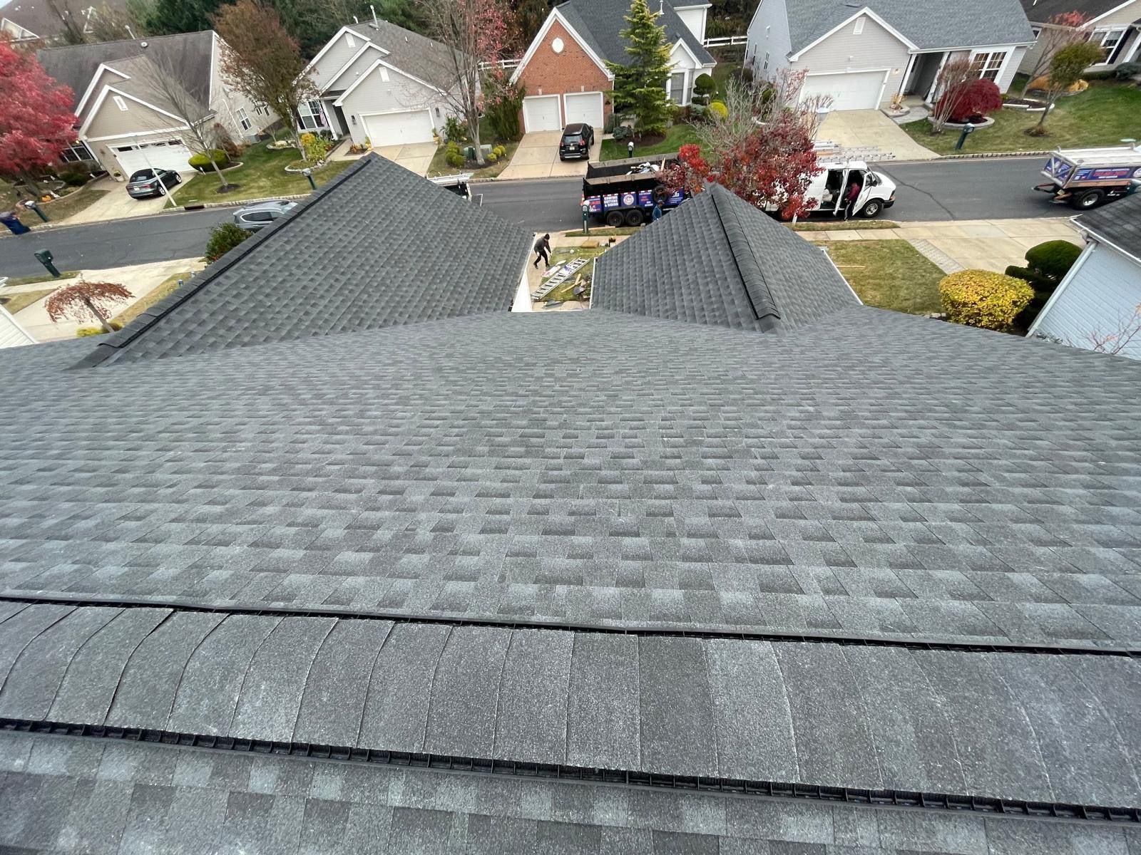An aerial view of a roof of a house in a residential neighborhood.