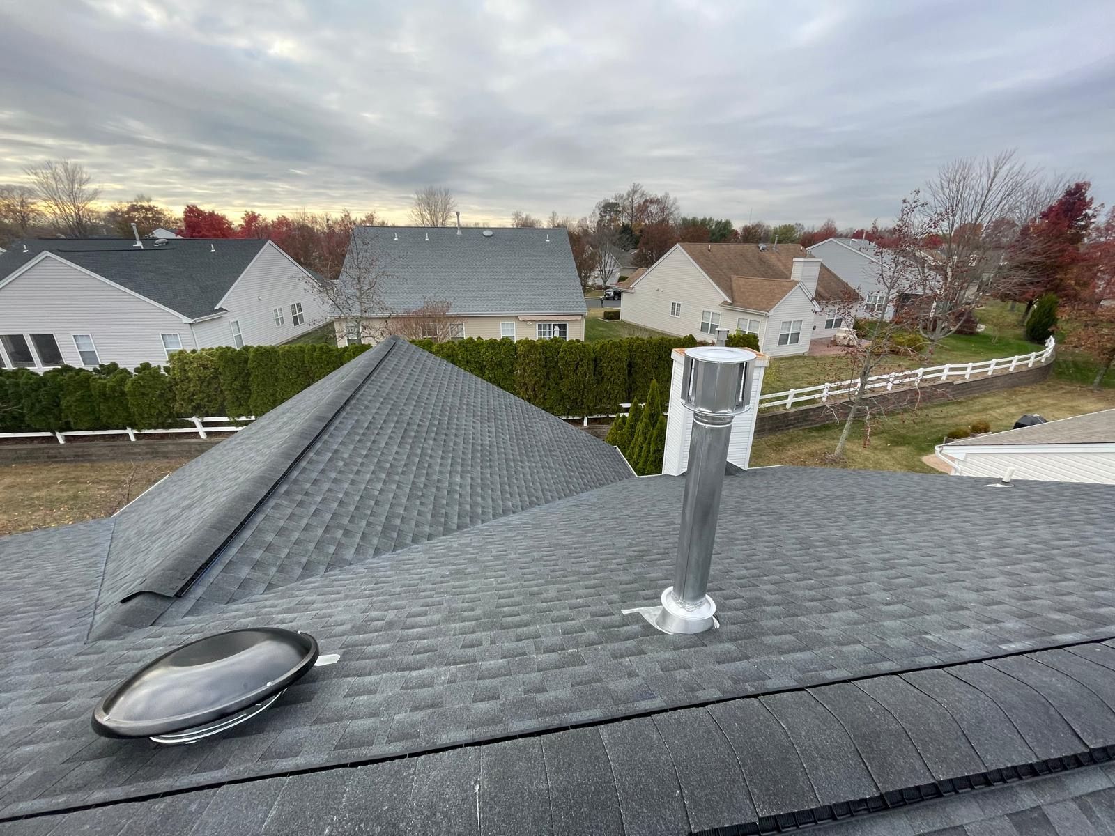 A roof with a chimney and a skylight on it.