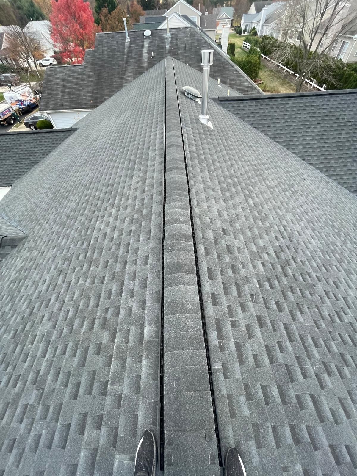 A person is standing on the roof of a house.