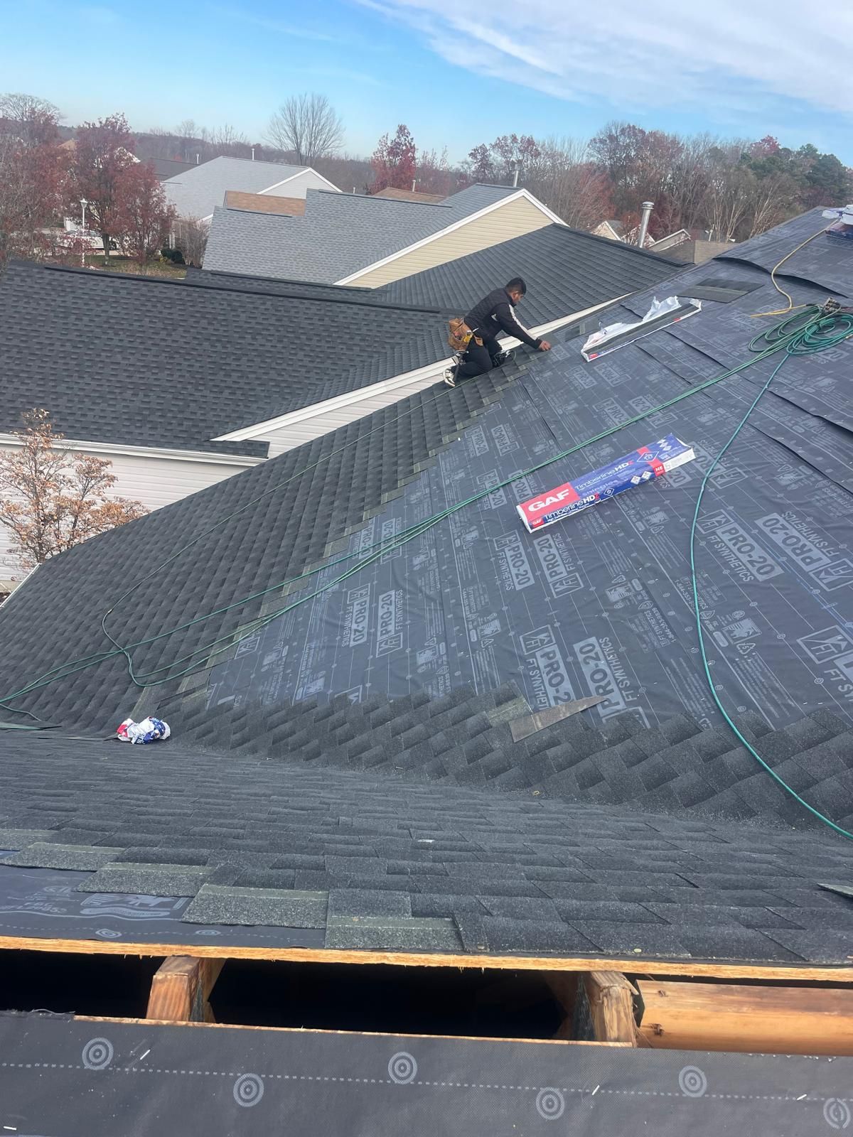 A man is working on the roof of a house.