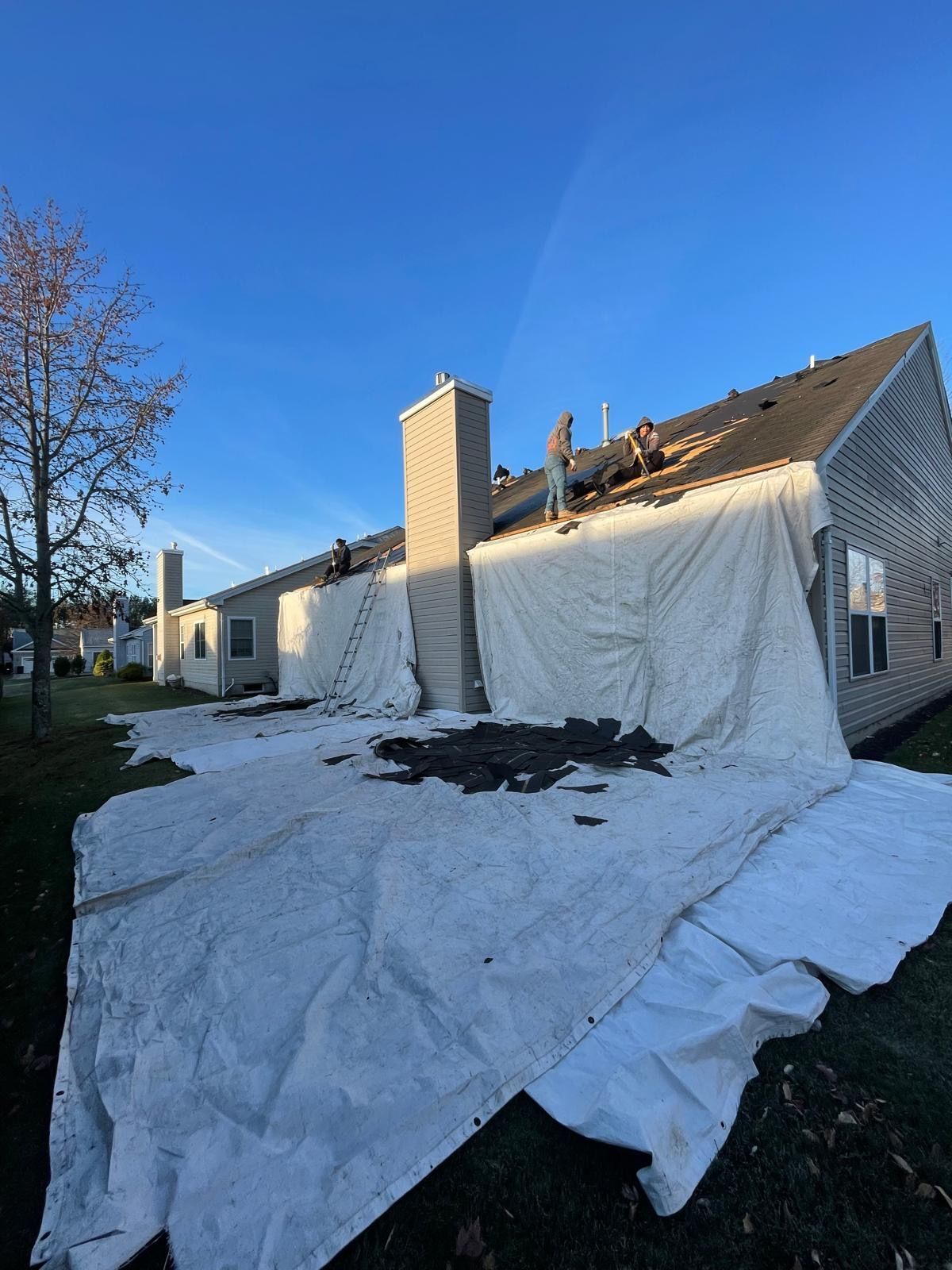 A house with a tarp on the ground in front of it