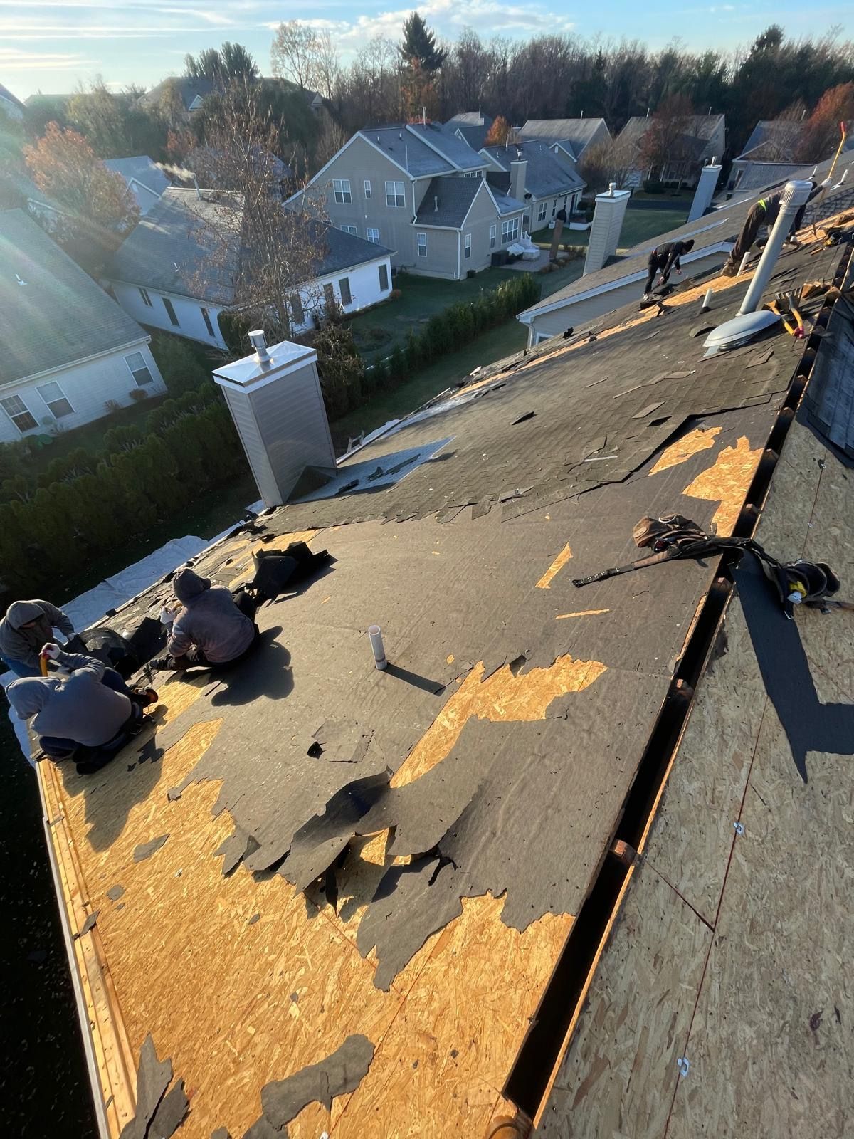 A group of people are working on the roof of a house.