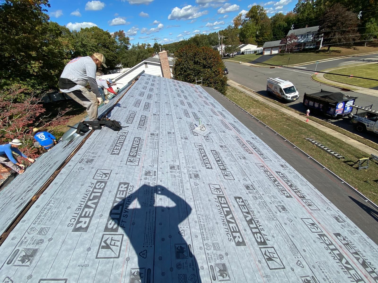 A group of people are working on the roof of a house.