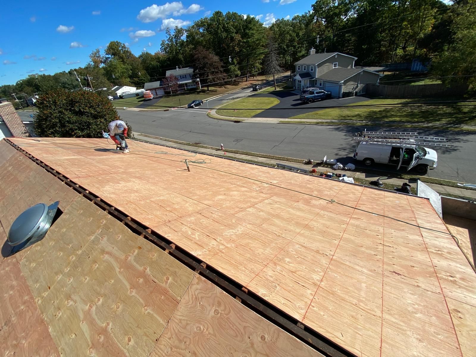 A man is working on the roof of a house.