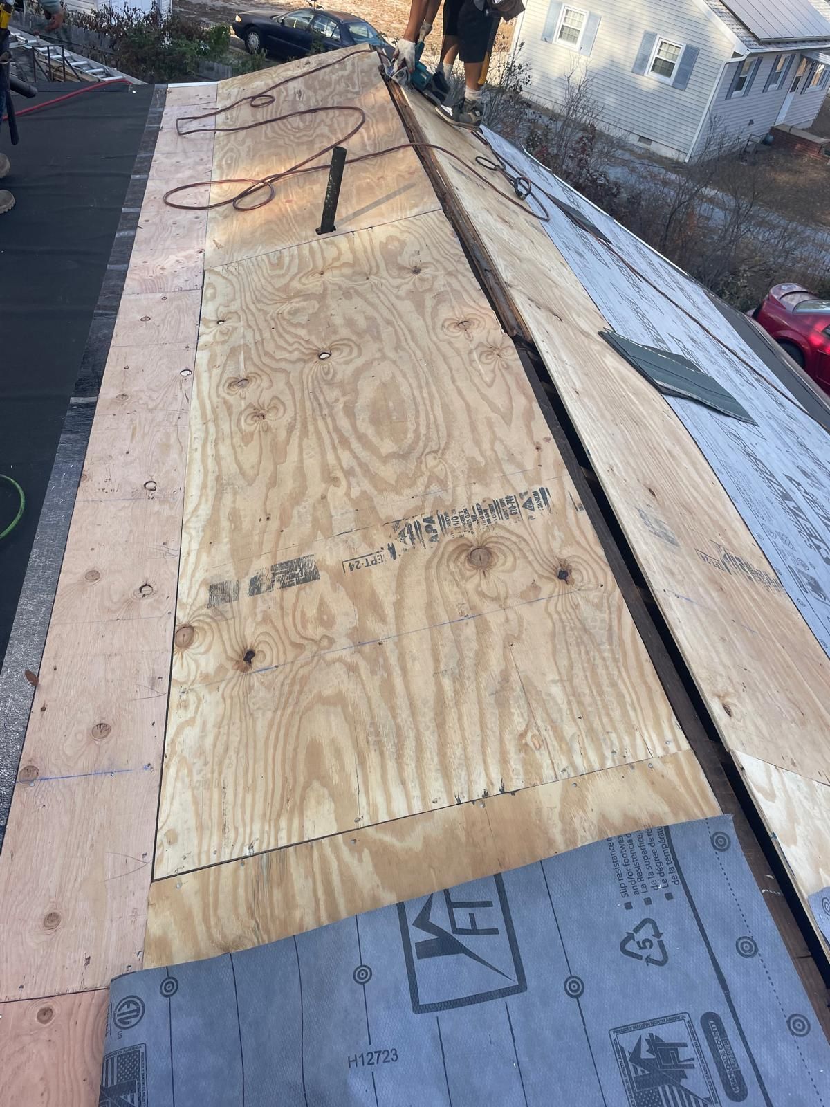 A roof is being built with plywood and shingles.
