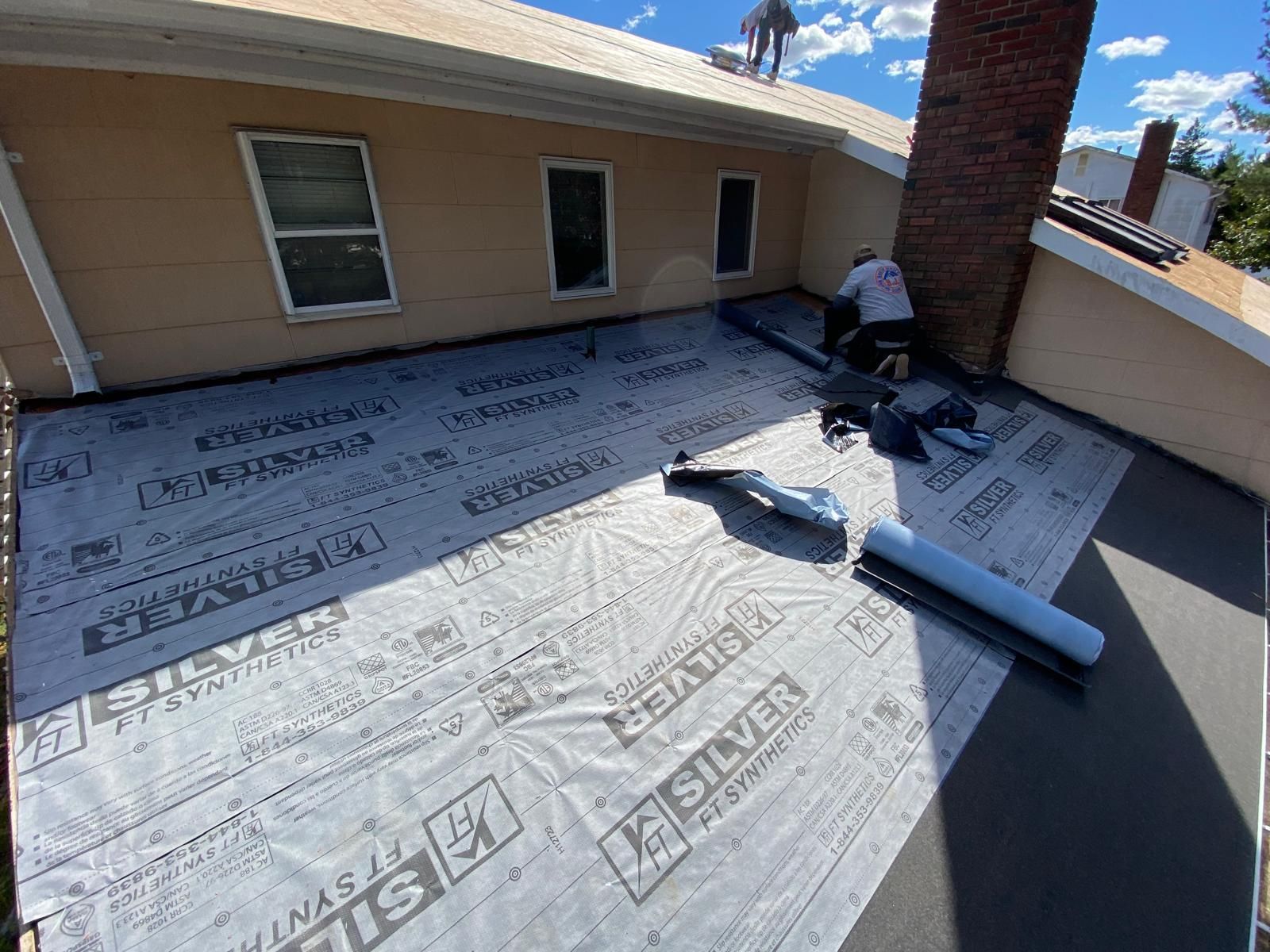 A man is working on the roof of a house.