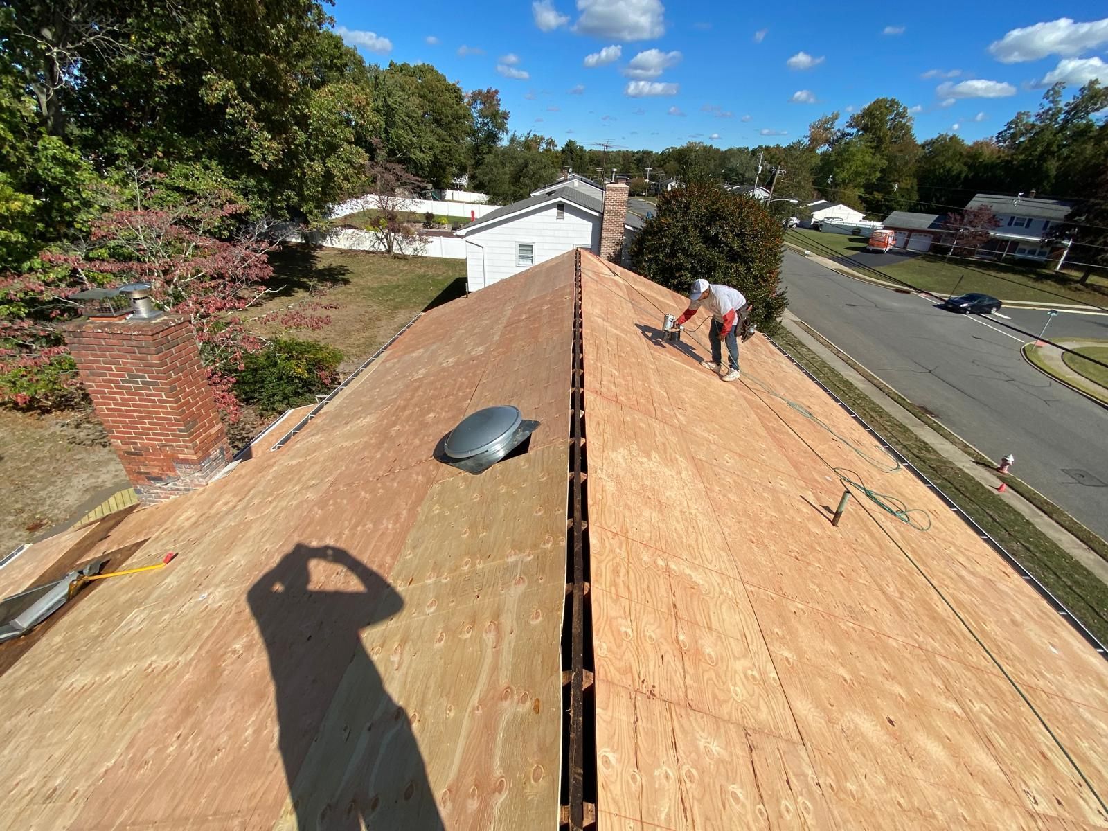 A man is working on the roof of a house.