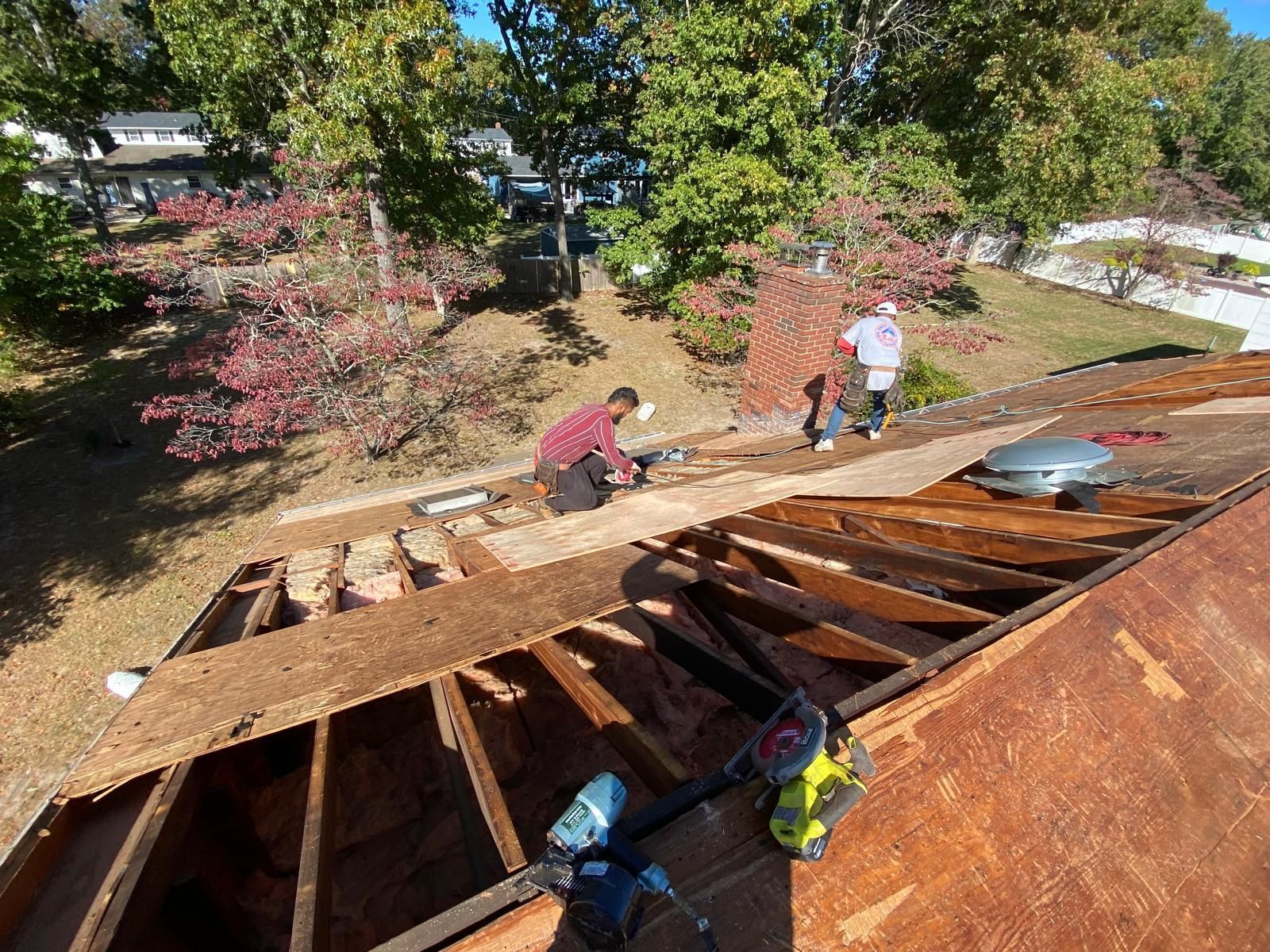 A man is working on the roof of a house.