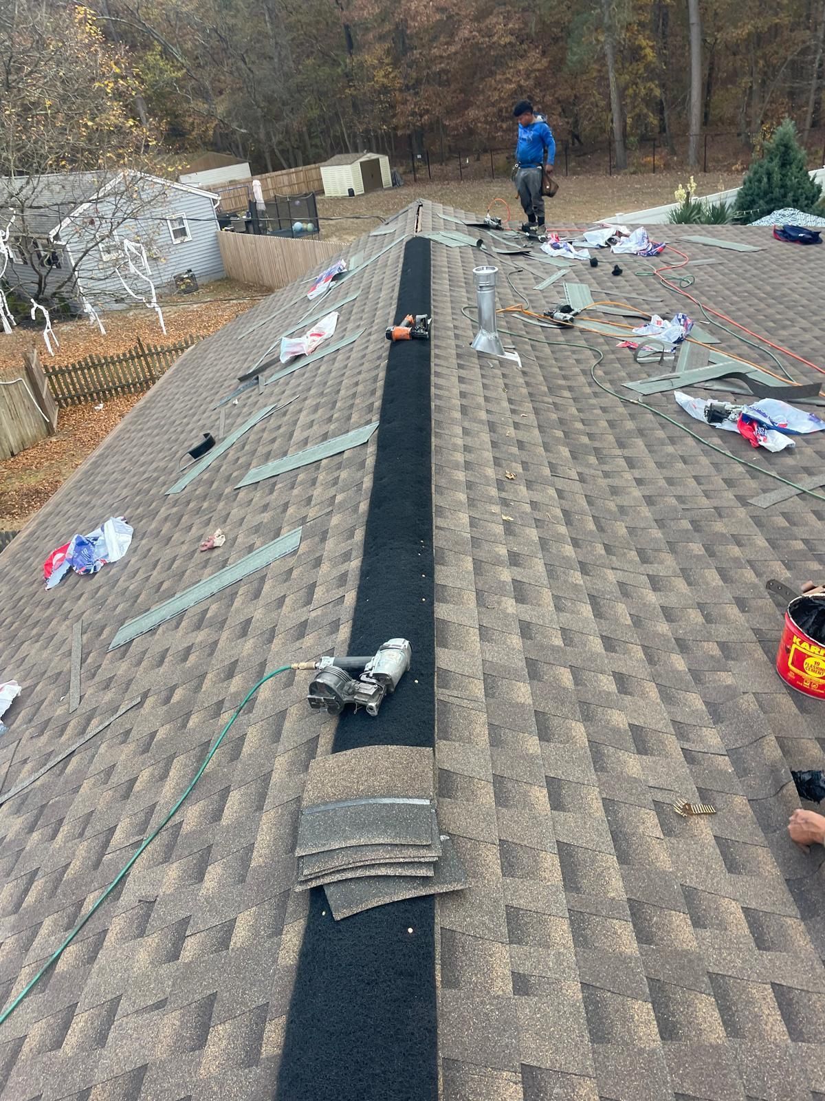 A man is working on the roof of a house.