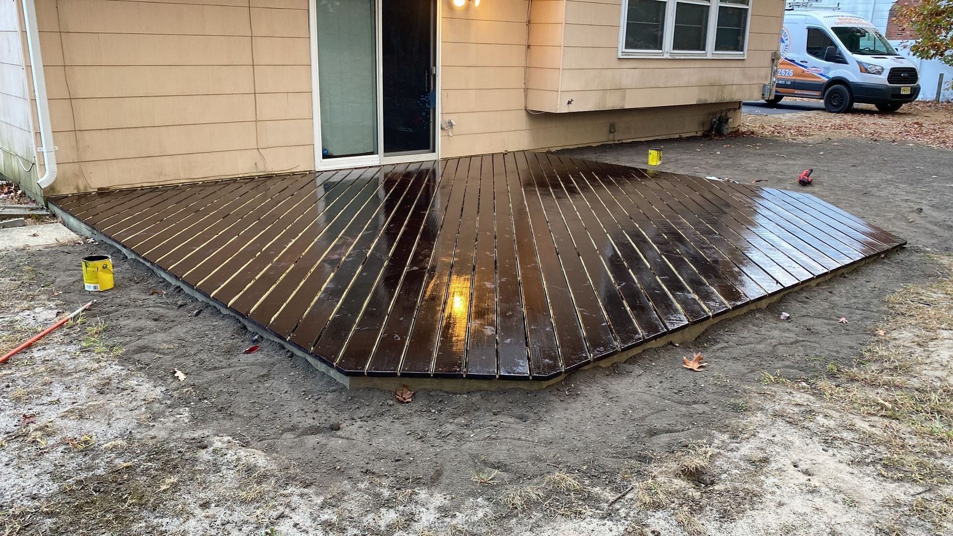 A wooden deck is sitting in front of a house.