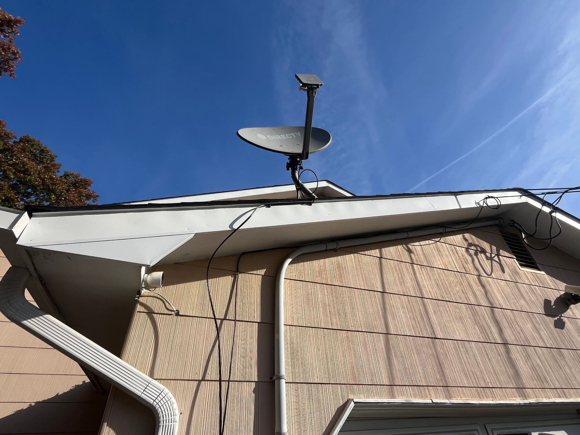 A satellite dish is mounted on the roof of a house