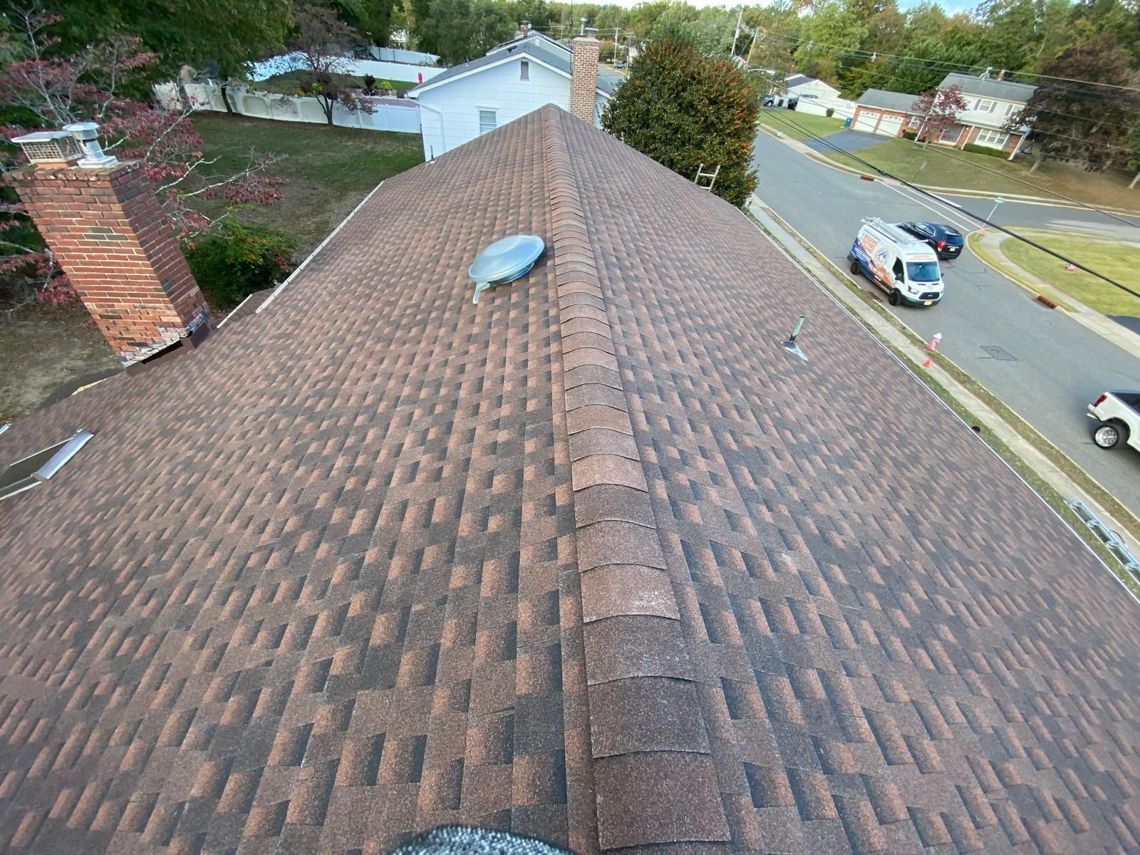An aerial view of a roof of a house in a residential area.
