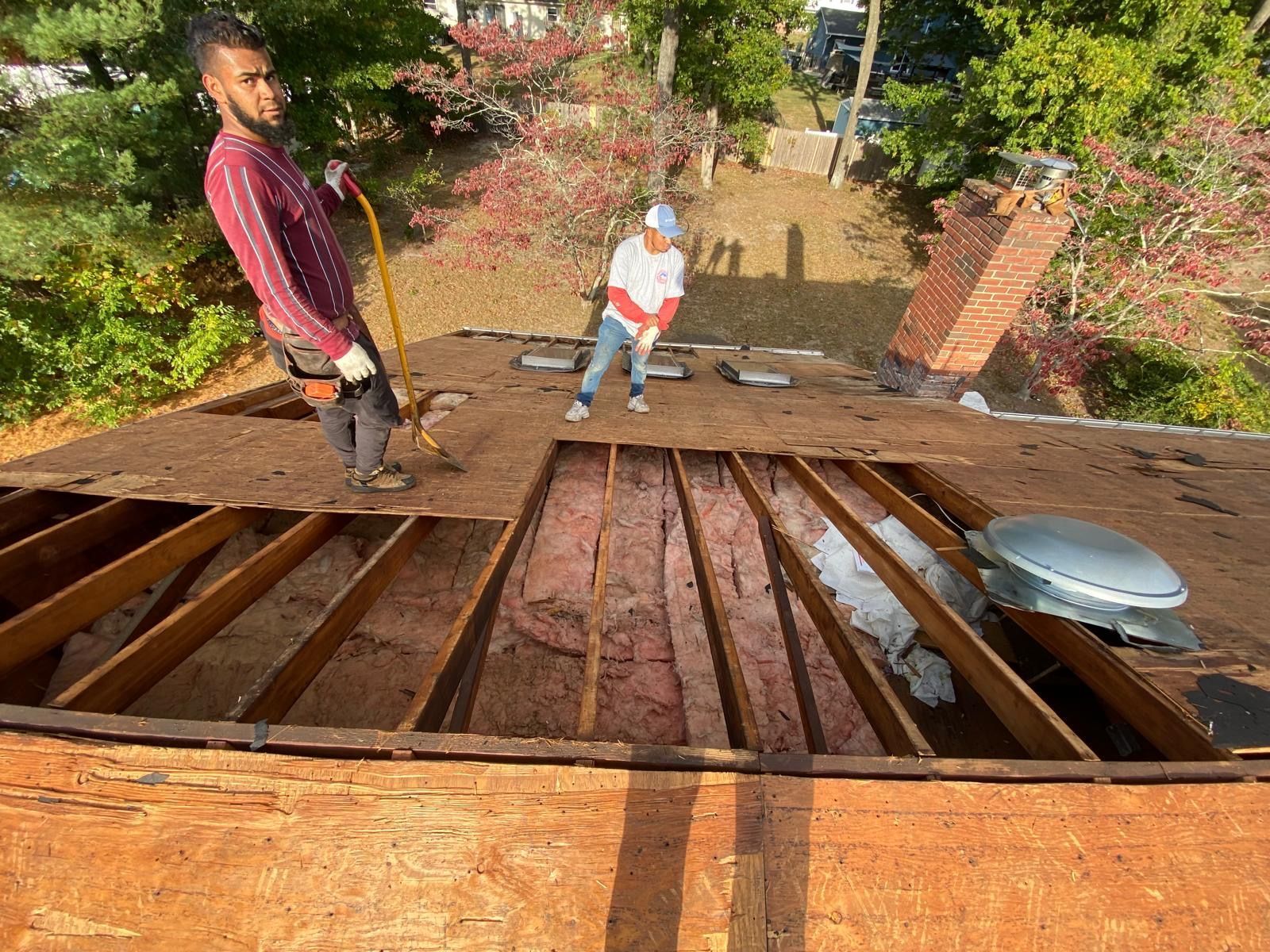 A man and a woman are working on the roof of a house.