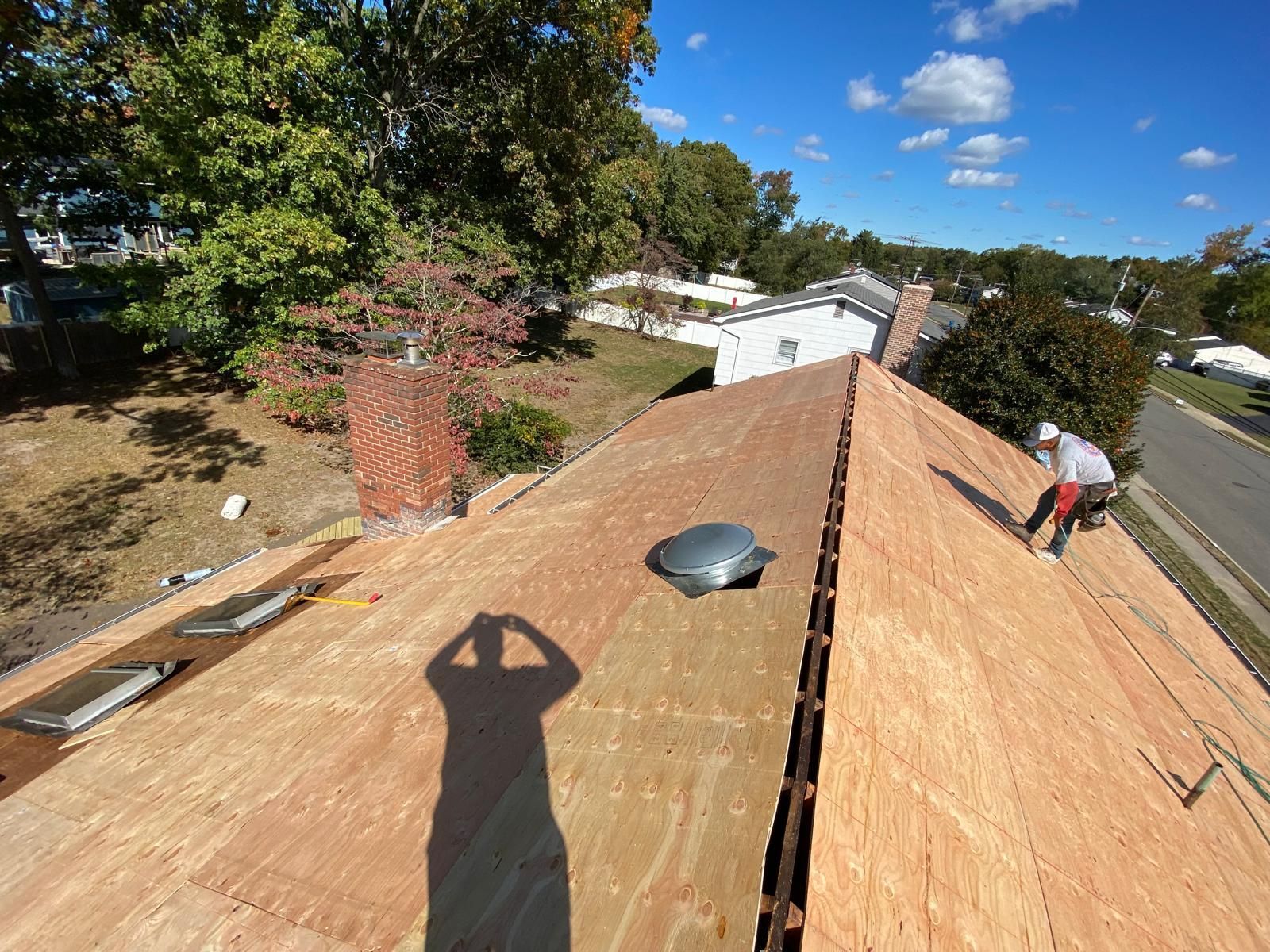 A man is working on the roof of a house.