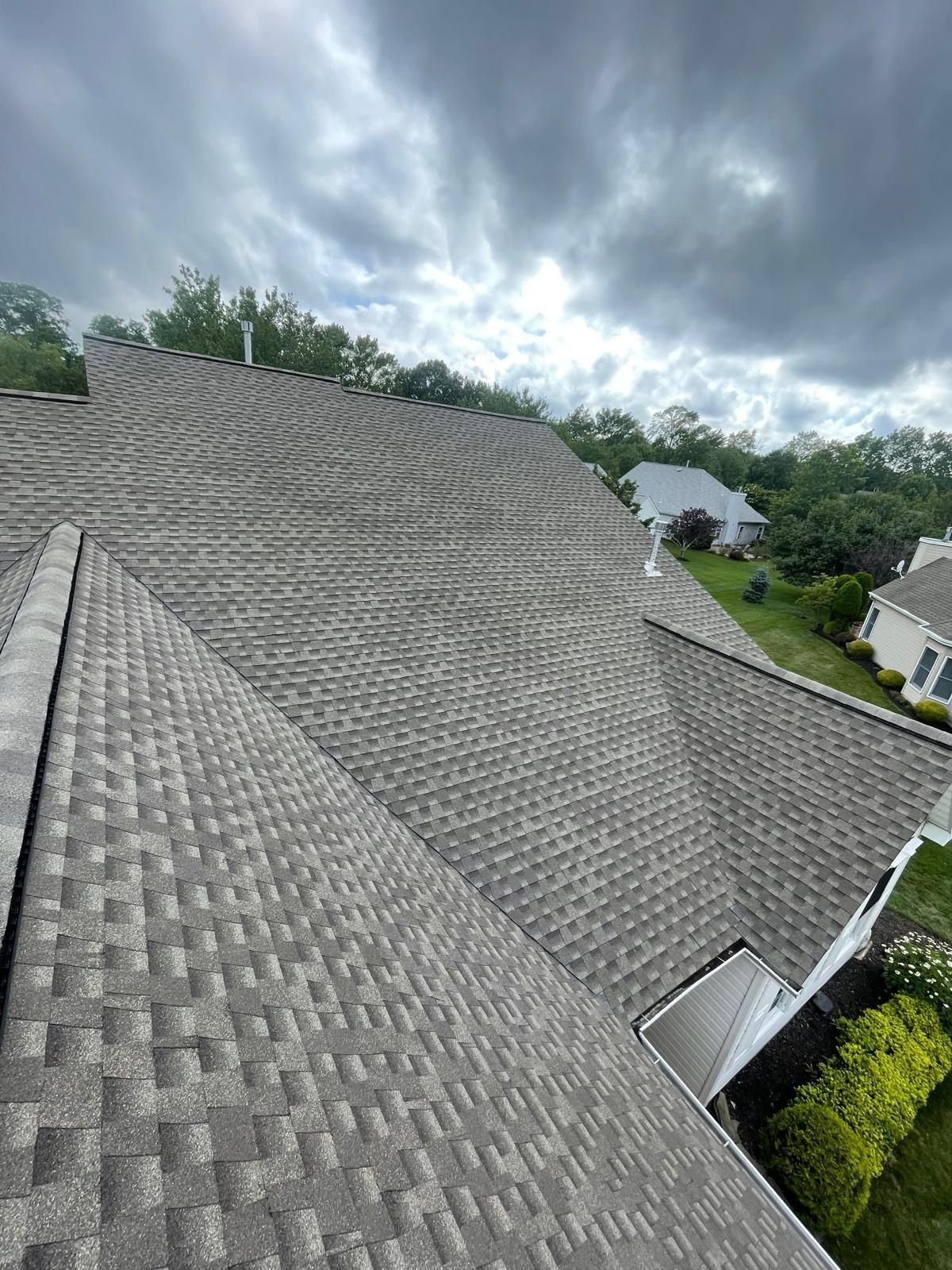 An aerial view of a roof with a cloudy sky in the background.