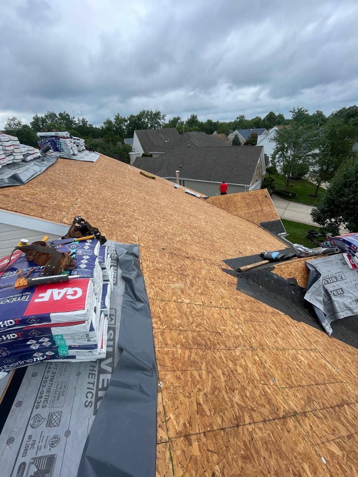 A roof is being installed on a house with a lot of plywood on it.