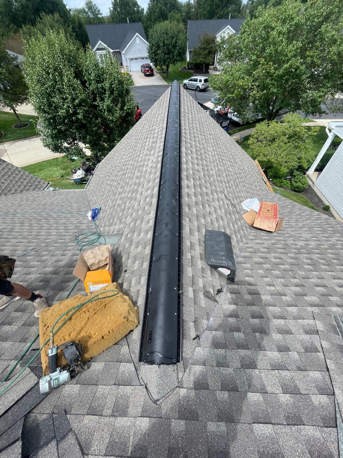 A man is working on the roof of a house.