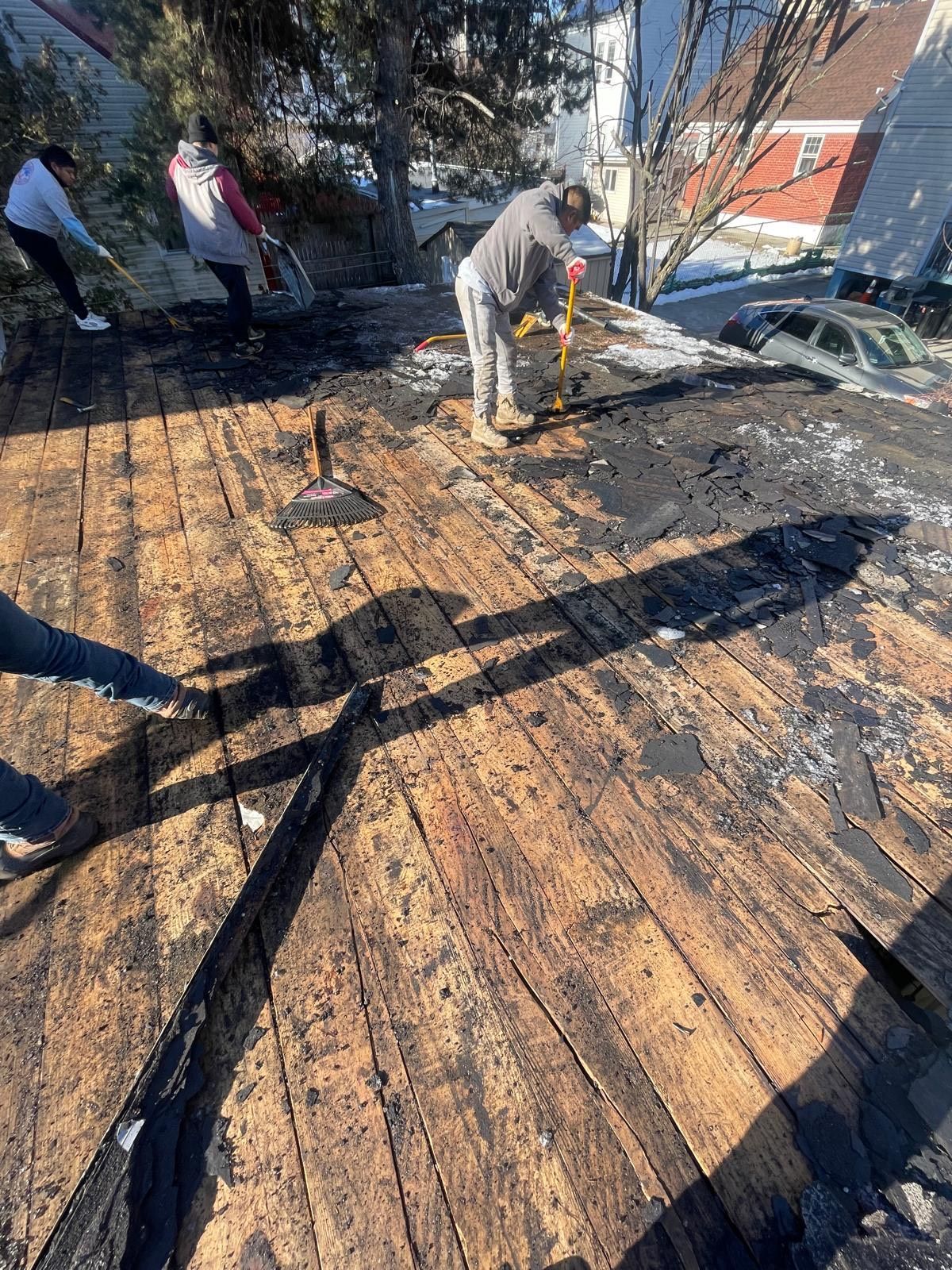 A group of people are working on a wooden roof.