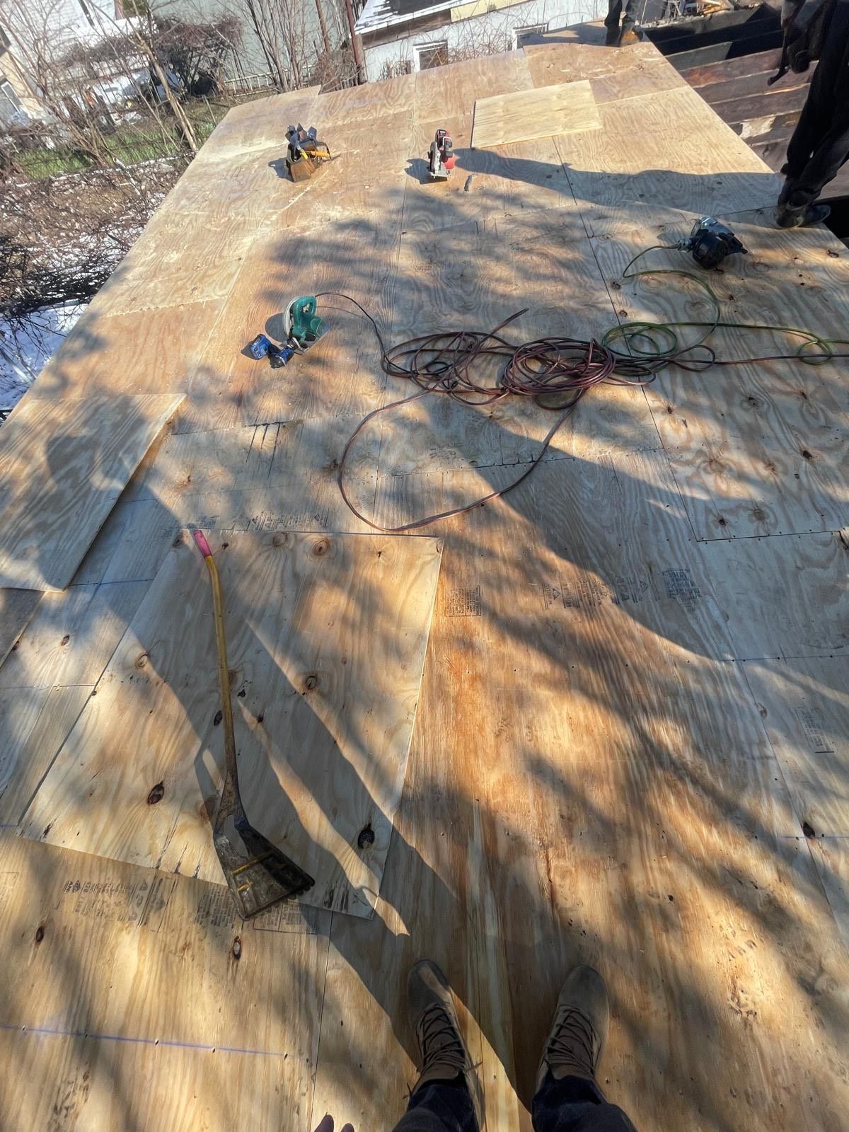 A person is standing on top of a wooden roof.