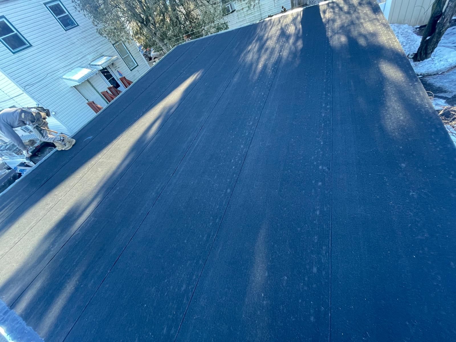 A person is working on the roof of a house.
