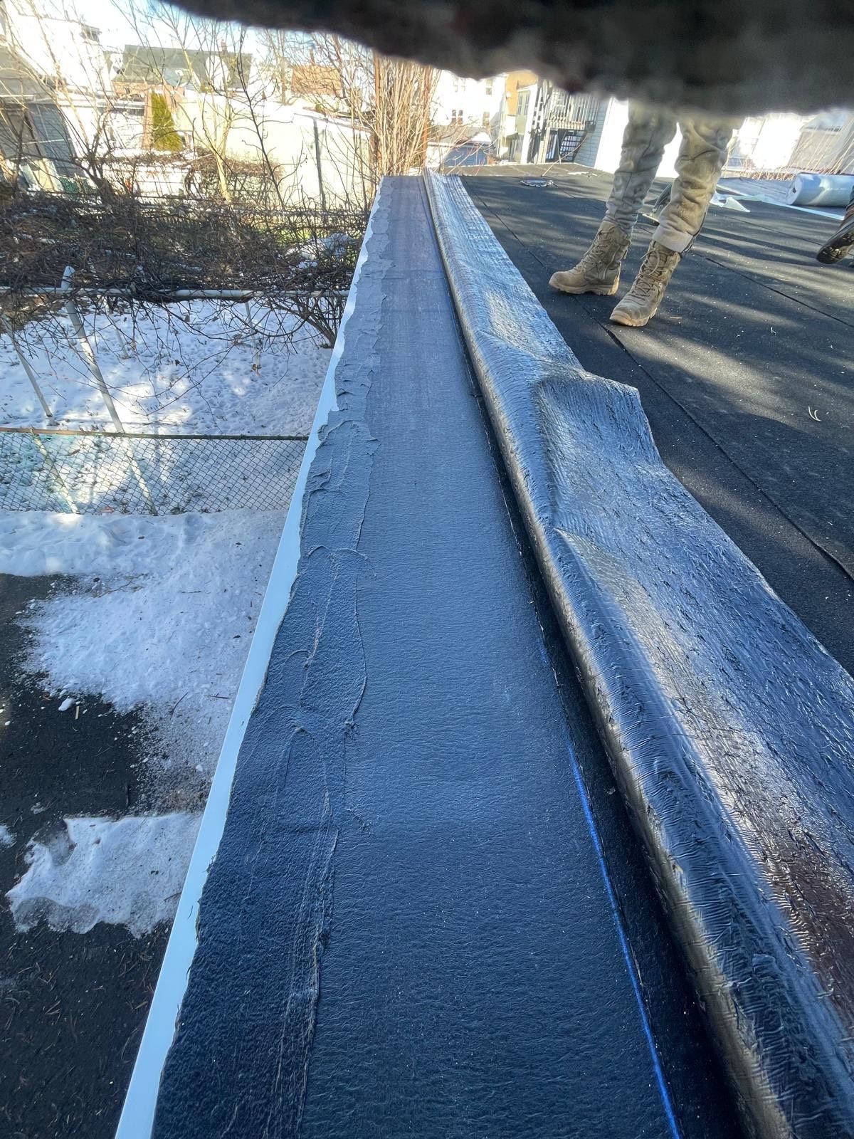 A person is standing next to a hose on a roof.