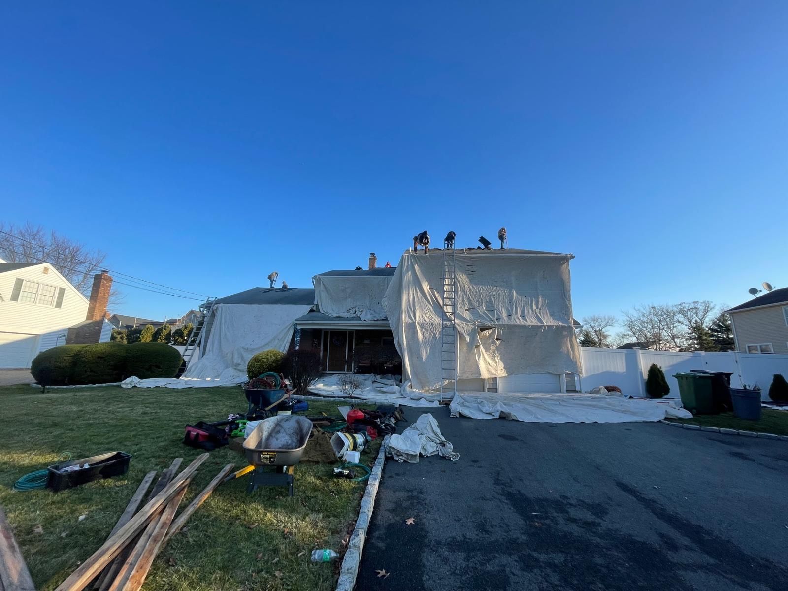 crew members are working on a roof of a house