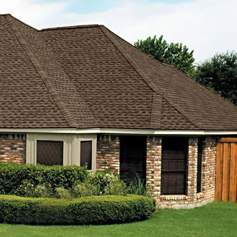 Brown-shingled roof on a brick home with dark-framed windows.