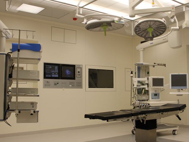 Operating room with surgical lights, equipment, and operating table.