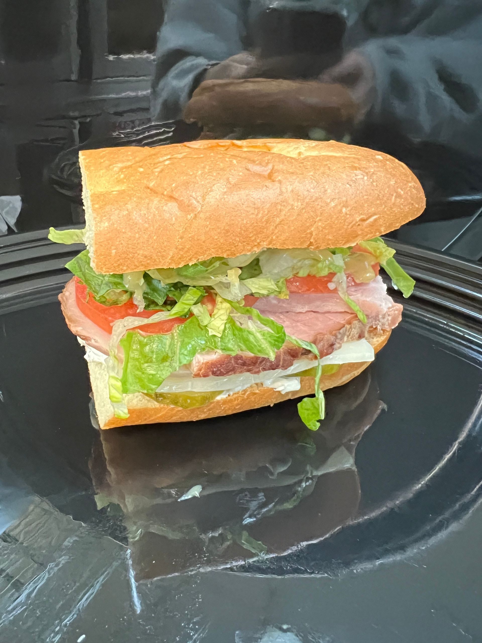 a sandwich is cut in half and sitting on a piece of tin foil