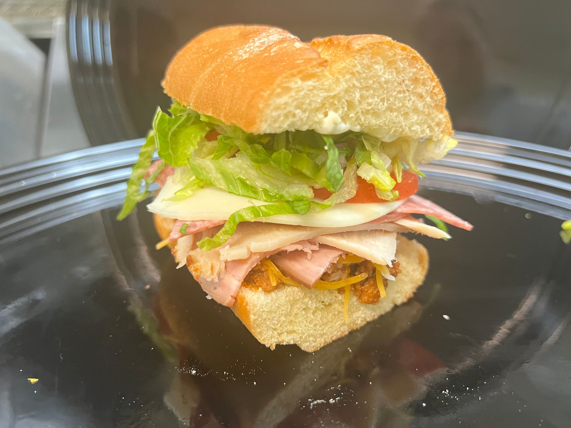 two sub sandwiches in a red basket with a pickle