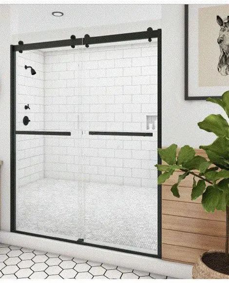 A shower with a black-framed sliding glass door against a white subway tile wall and hexagon-patterned floor tiles.