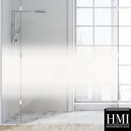 A frameless glass shower enclosure features a horizontal frosted gradient pattern, revealing a bathroom with marble floors.