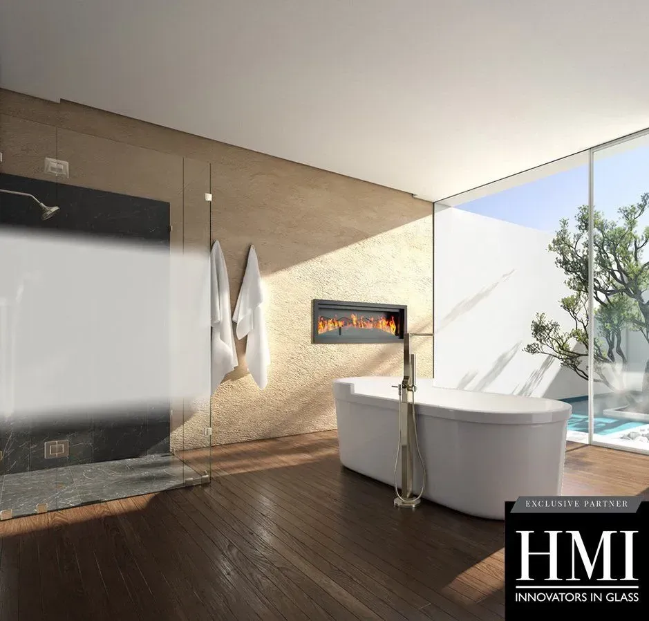 A modern bathroom with a glass-enclosed shower, a white soaking tub, and a wall-mounted fireplace overlooking a garden.