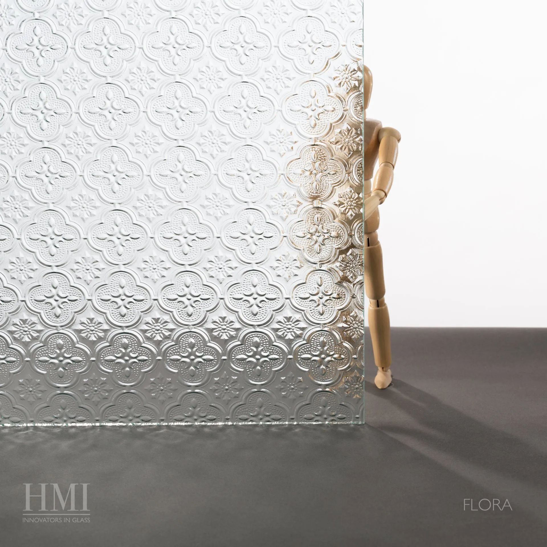 A sheet of patterned Flora glass obscuring a wooden artist mannequin, with